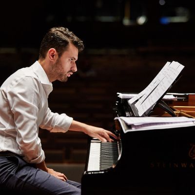 Student playing piano on stage